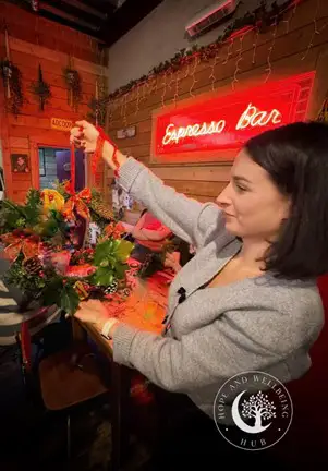 A woman holding up a wreath